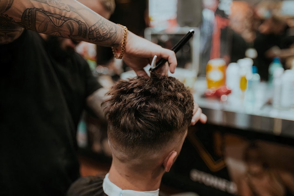 Barber knipt het haar van een klant met een tondeuse